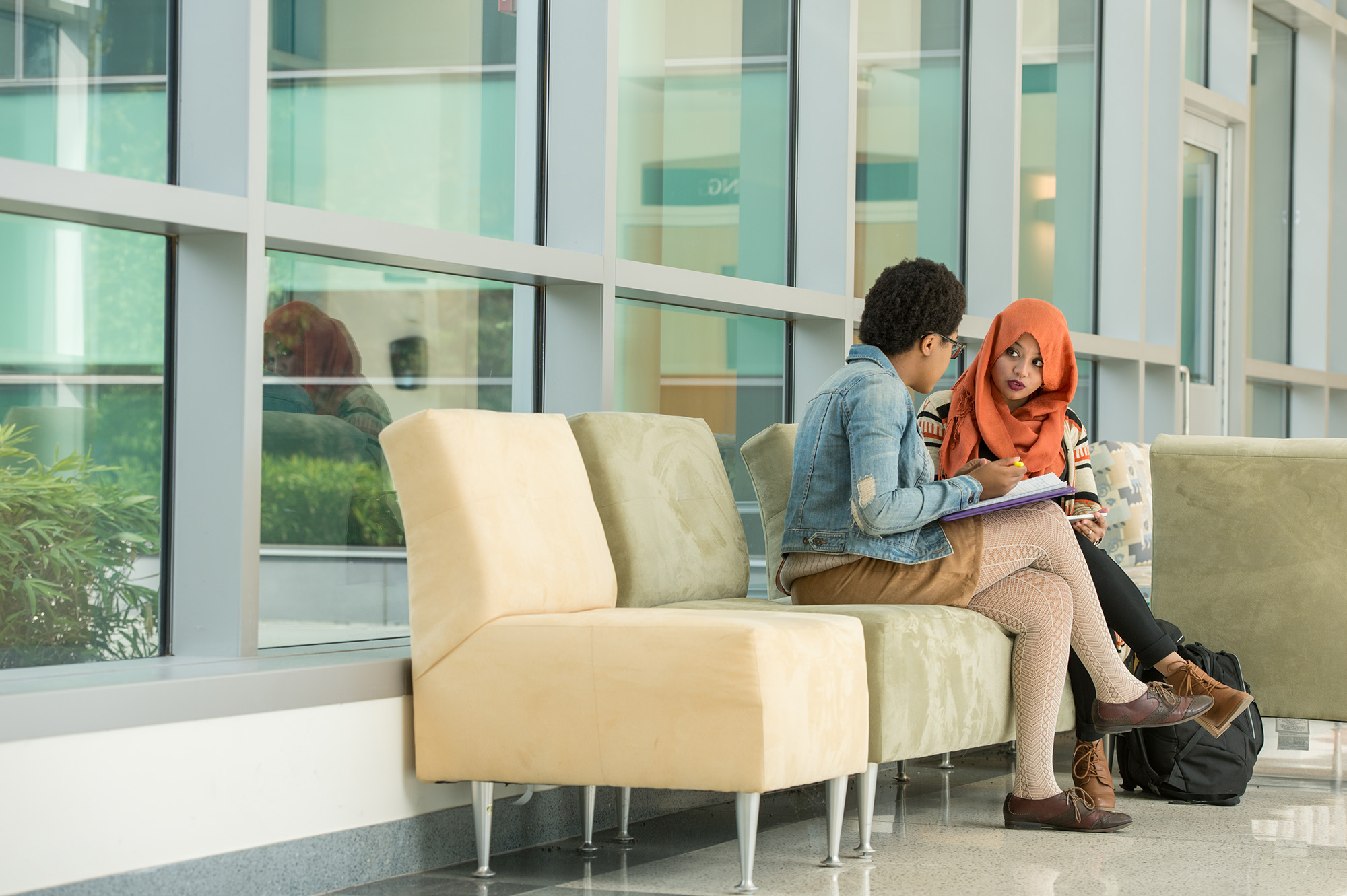 Two students sitting on a bench having a conversation