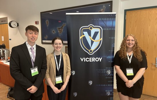 UAlbany students stand in front of VICEROY step and repeat banner.