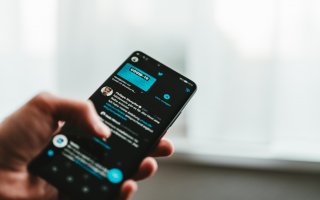 Photo of smartphone on Twitter with COVID-19 messaging