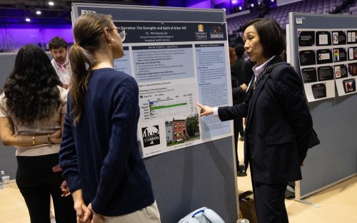 UAlbany Provost Carol Kim speaks with a student presenting on the floor of Broadview Center during Showcase 2025.